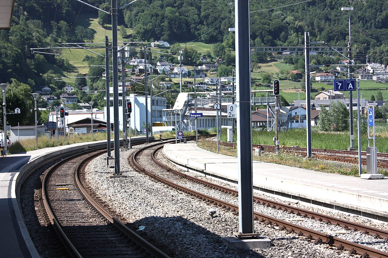 Perrons und Gleise des Bahnhofs Sargans vor grünen Berghängen, fotografiert 2026.